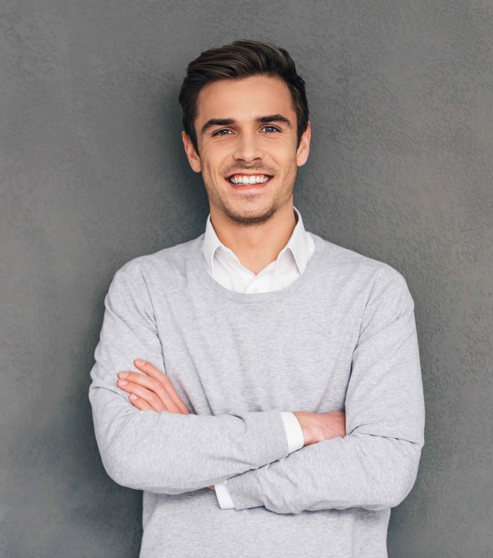 vecteezy_keep-smiling-confident-young-man-keeping-arms-crossed-and_13572704