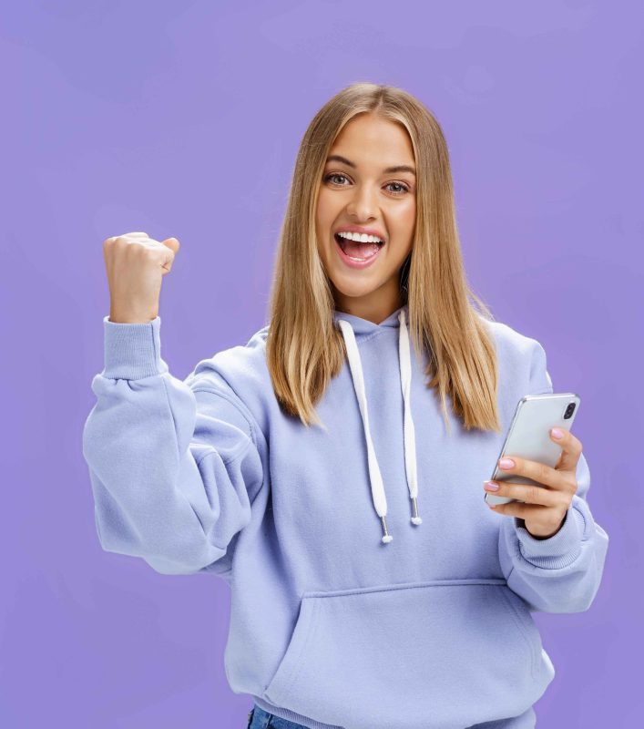 vecteezy_yes-we-did-it-pleased-excited-woman-in-hoodie-raising-fist_40147407